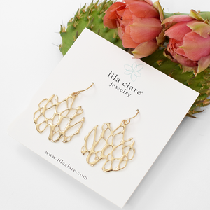 gold freeform cactus earrings on white card with prickly pear cactus