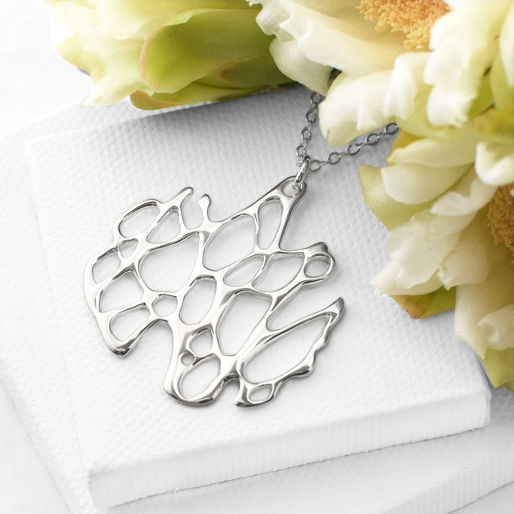 organic circle cactus silver necklace on white background