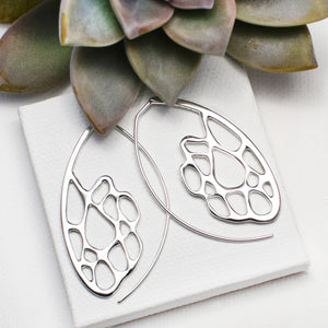 silver cactus skeleton hoops on white block with succulent accent