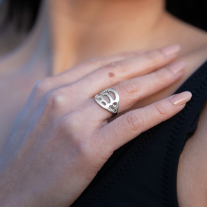 silver botanical signet ring on woman's hand