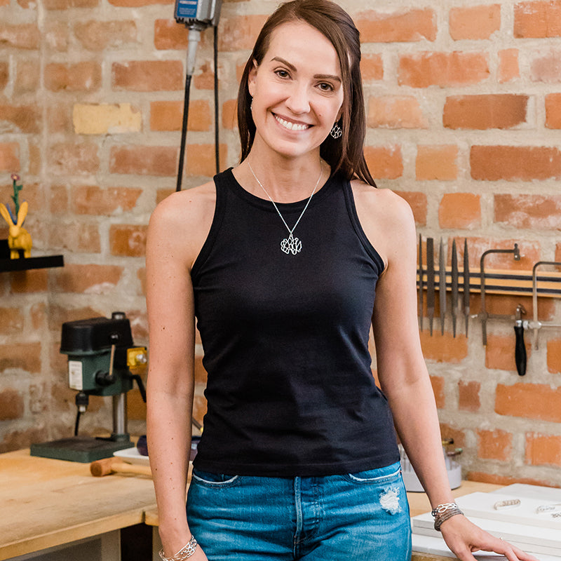 picture of local tucson jewelry artist Clare Johnston standing at her jewelry bench