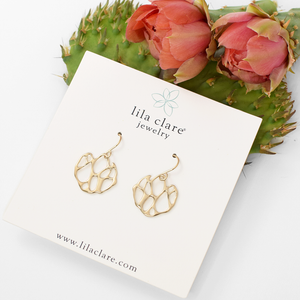 gold cactus earrings on white card with prickly pear cactus