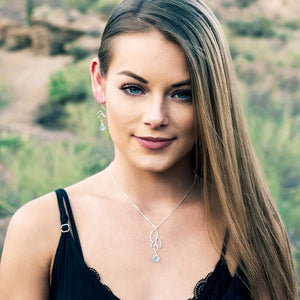 Image of a young woman wearing leaf and gemstone jewelry.