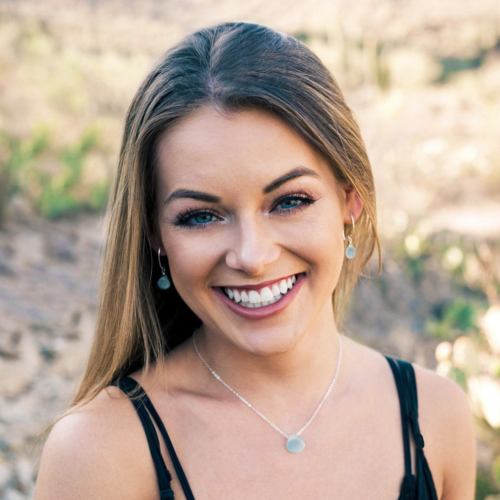 Image of a smiling woman wearing silver and chalcedony earrings and necklace jewelry set