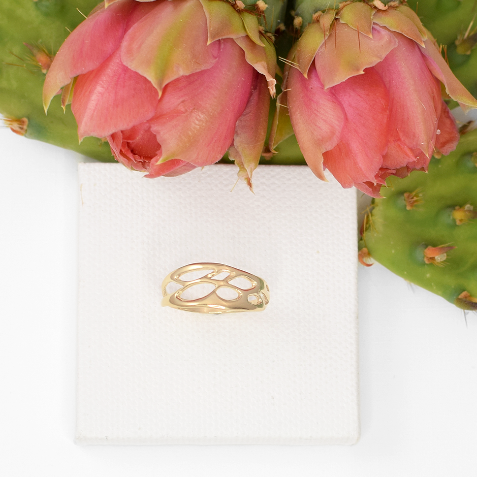 gold organic ring on white background with prickly pear cactus flowers
