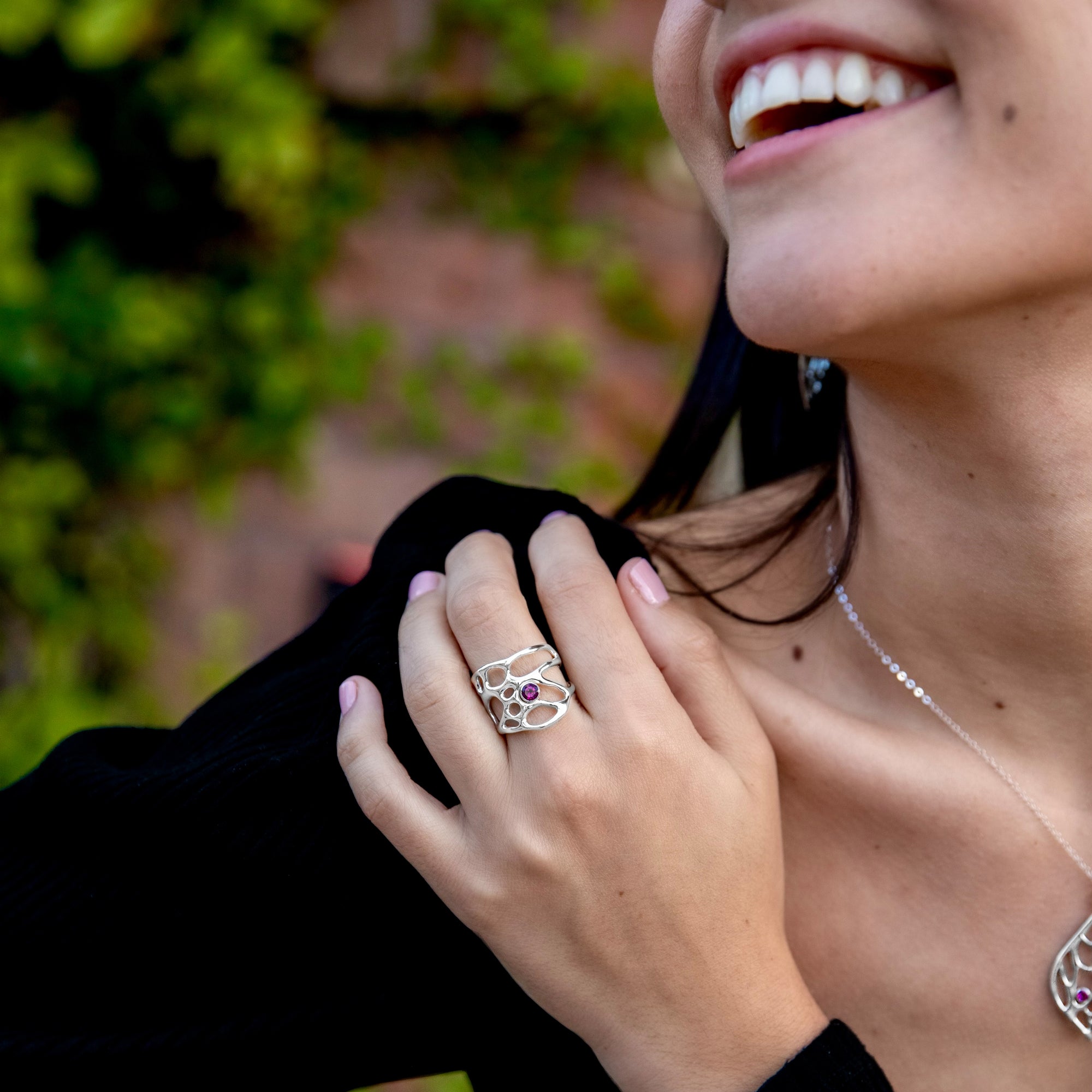 botanical engagement ring with gem on smiling woman's hand